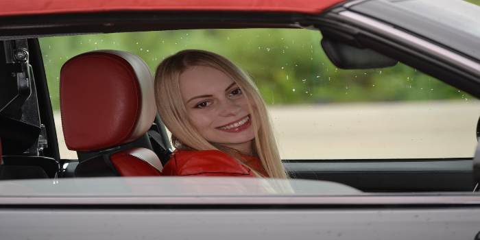 Frau lächelt aus einem Auto