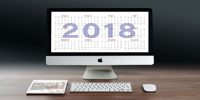 Bild von einem PC Bildschirm der auf einen Online-Kalender zeigt und ein Tablet, einen Maus und eine Tastatur liegen davor
