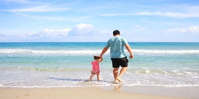 Vater und Kind gehen am Strand spazieren