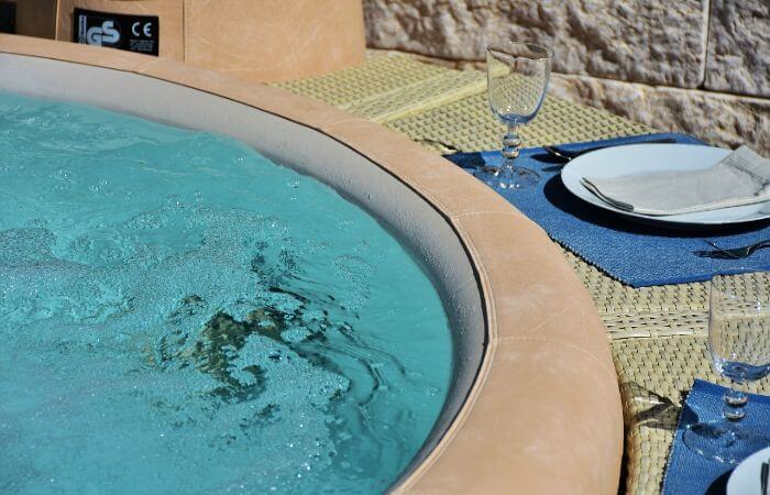 ein Whirlpool mit zwei Gläsern und Tellern am Rand 