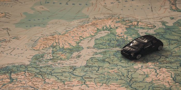 Das Bild zeigt eine Landkarte von Skandinavien mit einem Modellauto drauf
