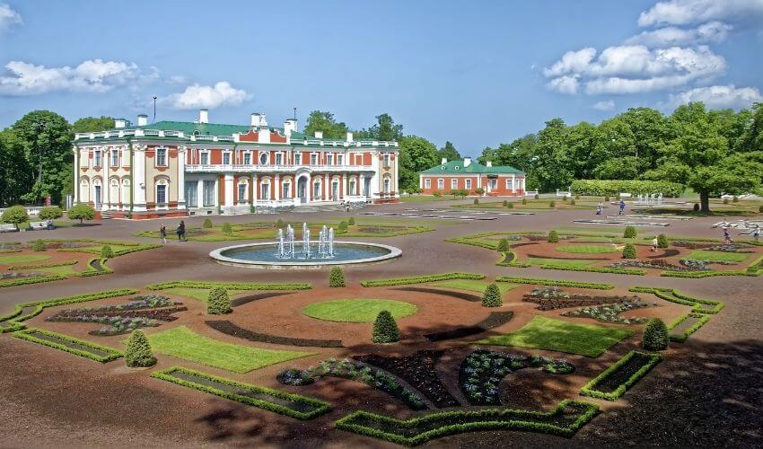 Gut restauriertes Schloss mit aufwendig angelegtem Garten davor.