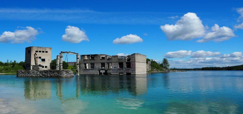 Ein verfallenes Gebäude steht neben und in einem See.