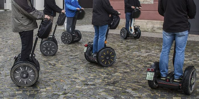 Segway Tour 6 Segways sind auf Pflastersteinen unterwegs