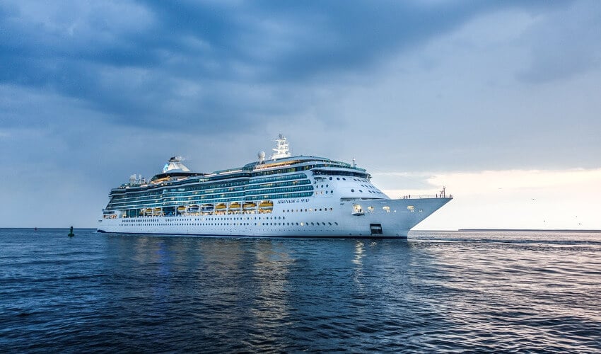 Ein großes Kreuzfahrtschiff auf offener See bei Abenddämmerung.