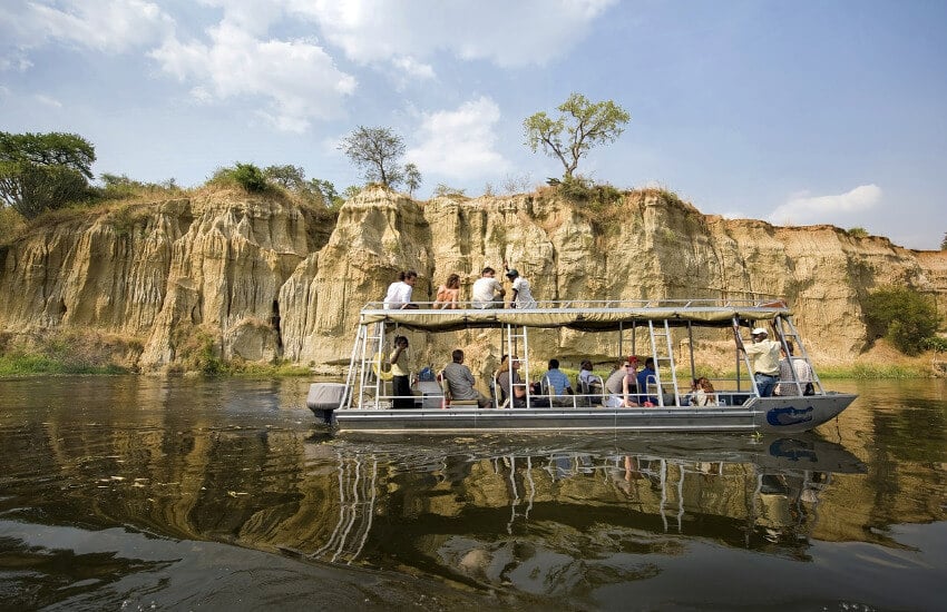Ein Boot mit 15-20 Touristen unterwegs auf einen Fluss im Murchison Nationalpark.