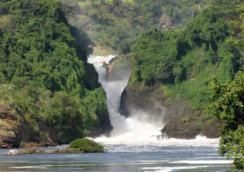 Ein schmaler Wasserfall zwischen mit Sträuchern bewachsenen Klippen.