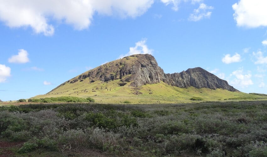 Ein Berg umgeben von seichten Gestrüpp und Gras.